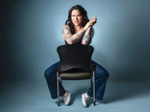 Woman with tattoos sitting on chair
